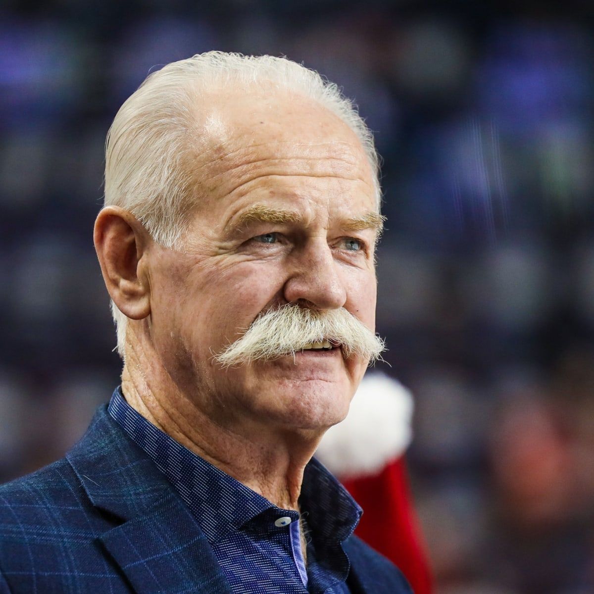 Lanny Mcdonald. Headshot of Lanny Mcdonald wearing a navy plaid jacket over a blue collared shirt.