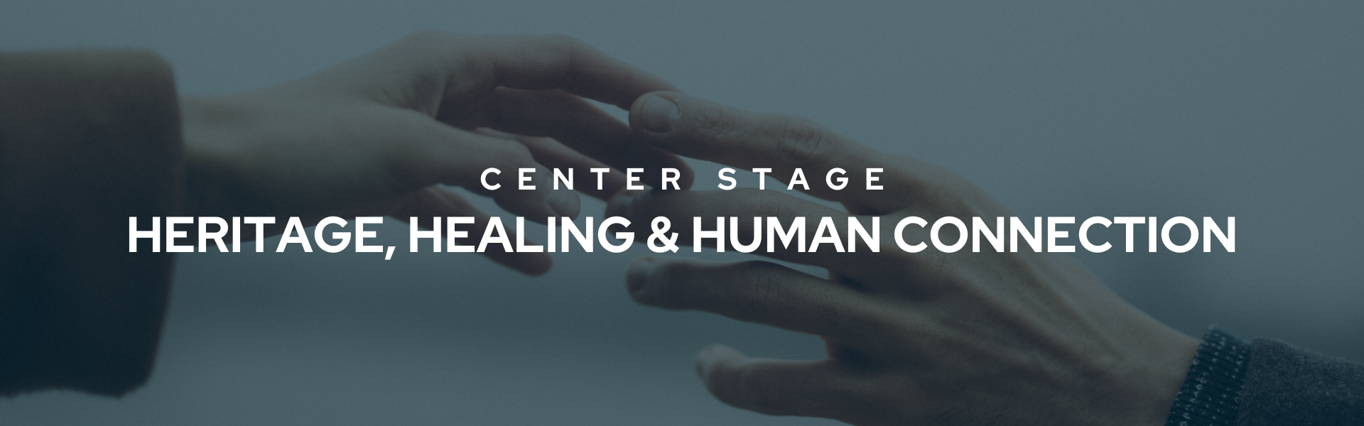 Banner that reads "Center Stage May Heritage, Healing & Human Connection" in bold white font. The background is an image of two hands reaching out for each other.