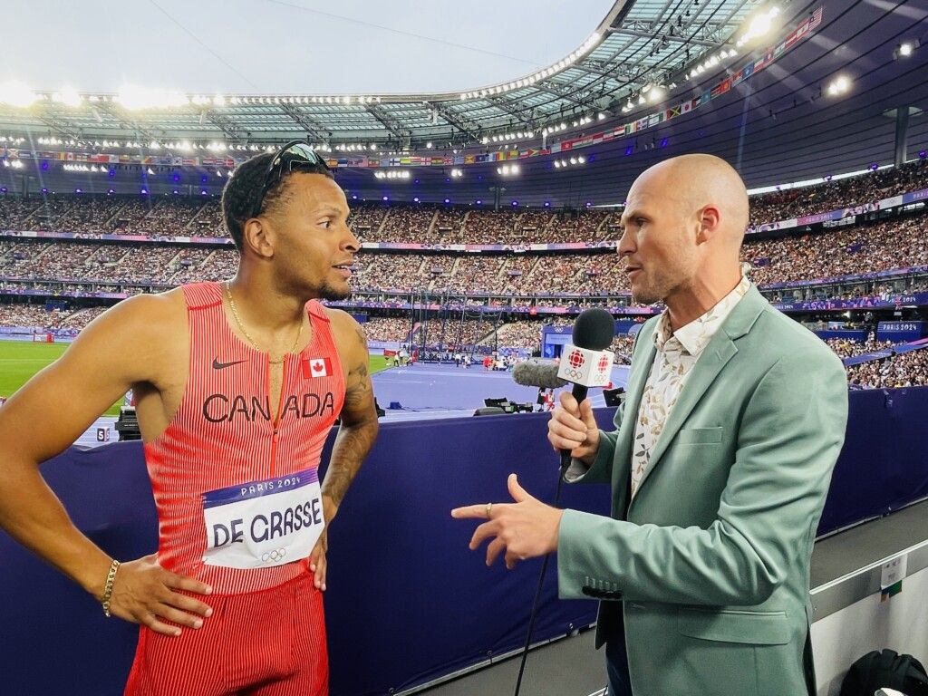 Devin Heroux interviewing Canadian Olympian, Andre De Grasse, next to the stadium track at the Paris Olympics.