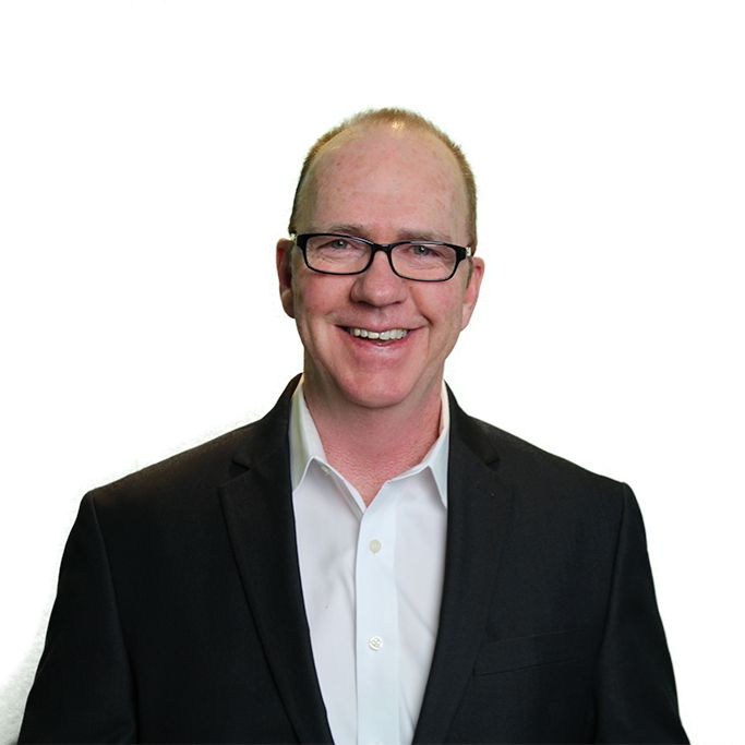 Eddit LeMoine. Headshot of Eddit LeMoine wearing a black suit over a light blue shirt. He is posing in front of a bright white background.