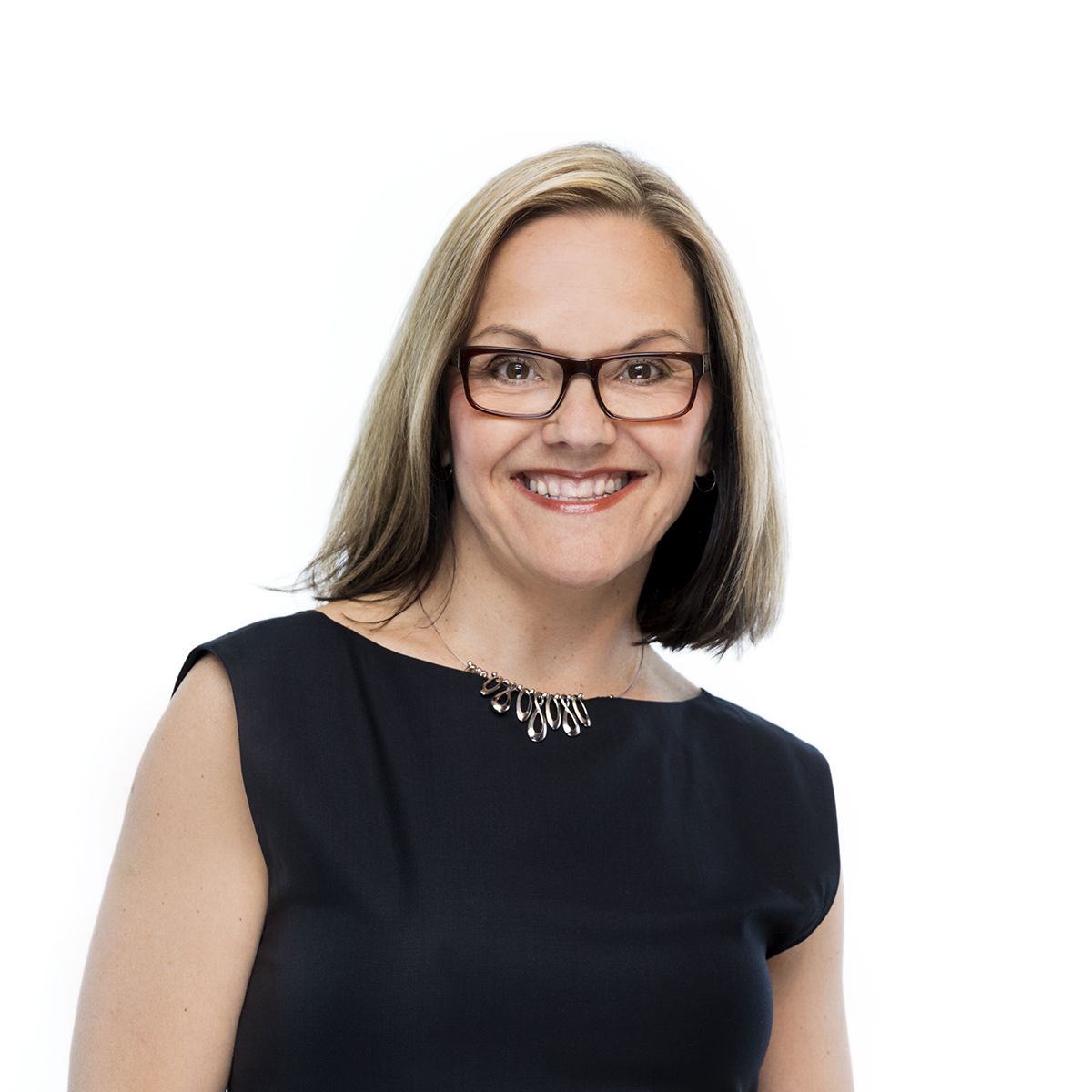 Michelle Cederberg. Headshot of Michelle Cederberg wearing a black short sleeve top and black framed glasses. She is posing in front of a bright white backgroud.