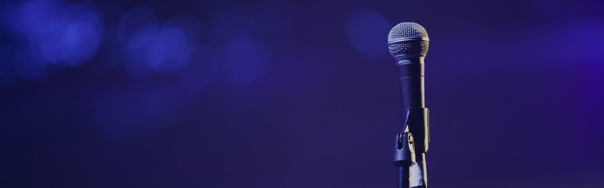 Decorative banner to depict the topic "Keynote Speaking Industry Trends". There is a microphone on a mic stand.