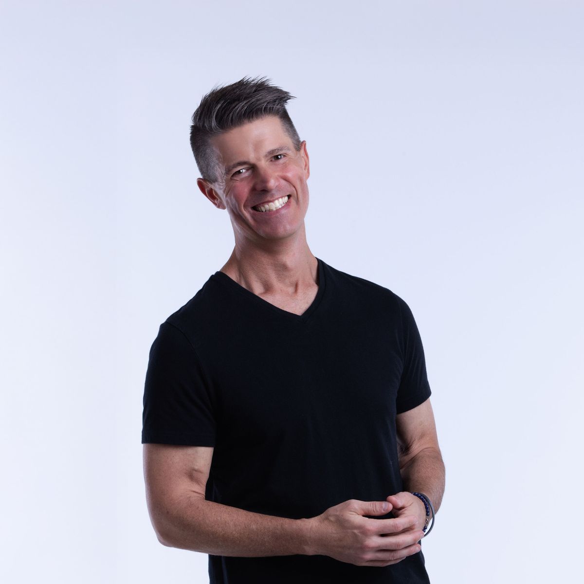 Rich Bracken. Headshot of Rich Bracken wearing a black t-shirt, standing in front of a white background.