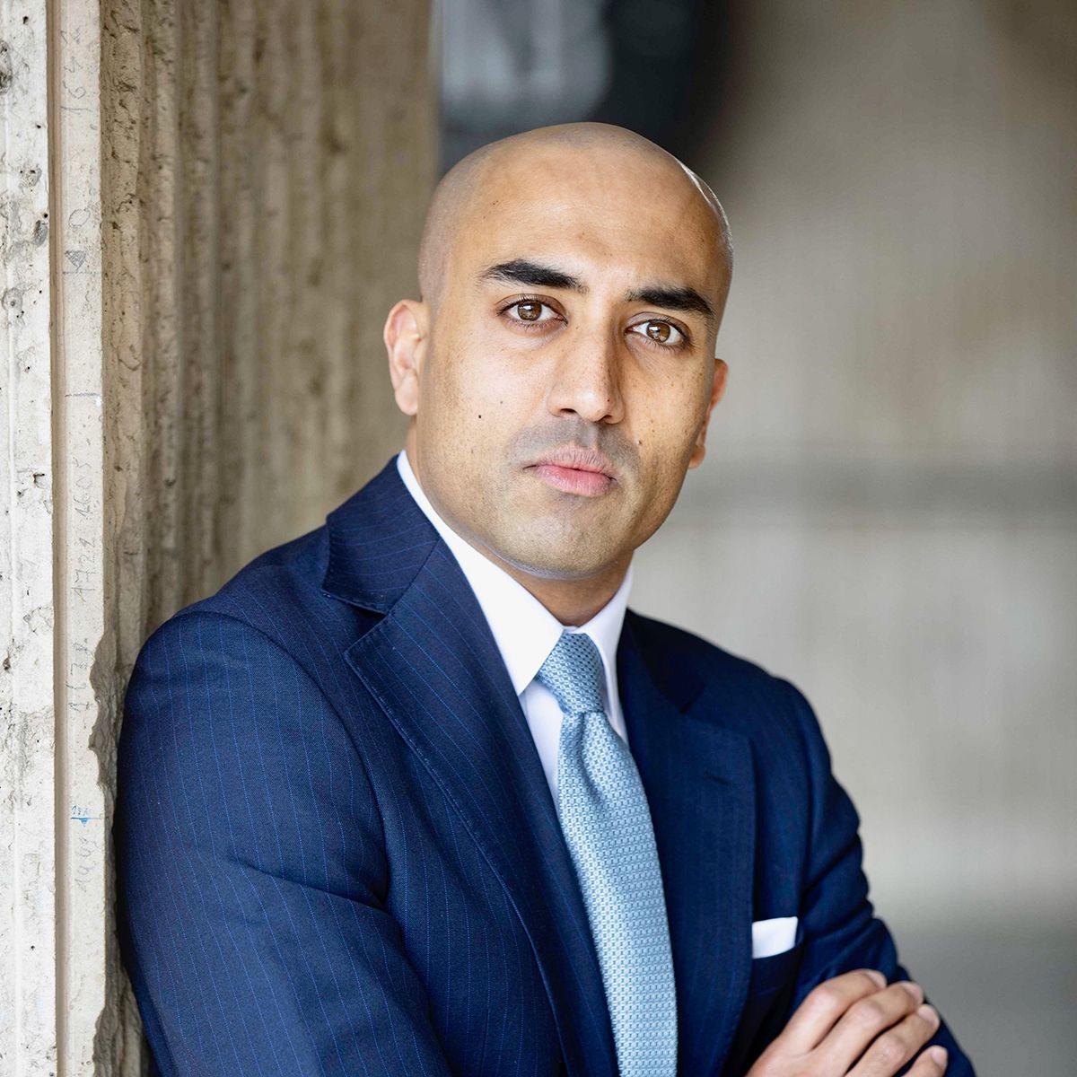 Professional headshot of Abishur Prakash wearing a blue suit
